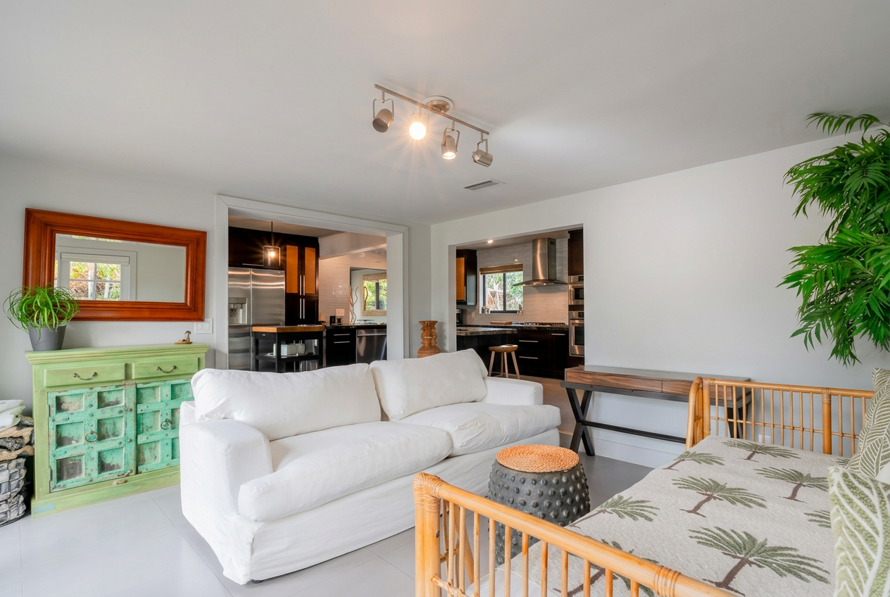 Open living room with white slipcover sofa, vintage green cabinet, and view to kitchen